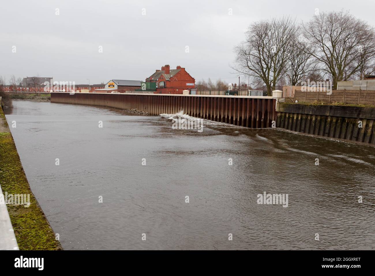 Il foro di Mersey Tidal si spacca contro le inondazioni di fronte a Wharf Street a Warrington Foto Stock