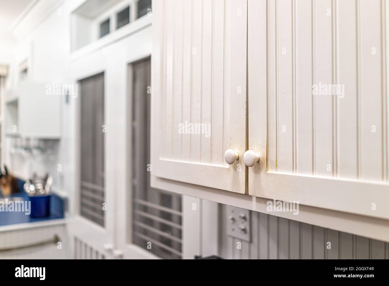 Moderno vintage stile cottage spiaggia bianco mobili in legno in casa primo piano con sfondo di cucina e finestra Foto Stock