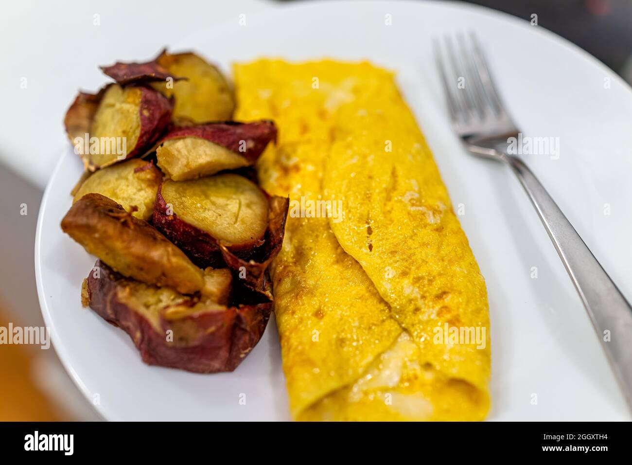 Frittata dolce giapponese e formaggio caldo uovo su piatto bianco cotto tradizionale ripiegato per la colazione mattina primo piano e forchetta Foto Stock