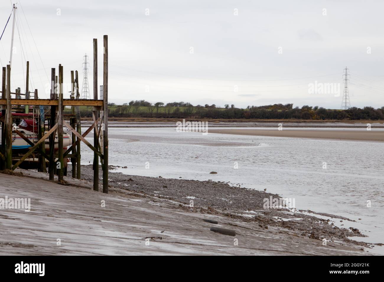 Una debole marea nel Wyre Estuary passando un molo nella zona di Skippool Creek sul Wyre Estuary Foto Stock