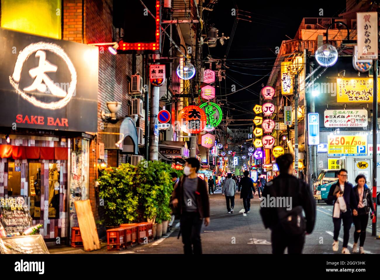 Osaka, Giappone - 13 Aprile 2019: Via Minami Namba con persone che camminano nella notte buia ed edifici al neon illuminati con lanterne sake bar di carta rossa Foto Stock