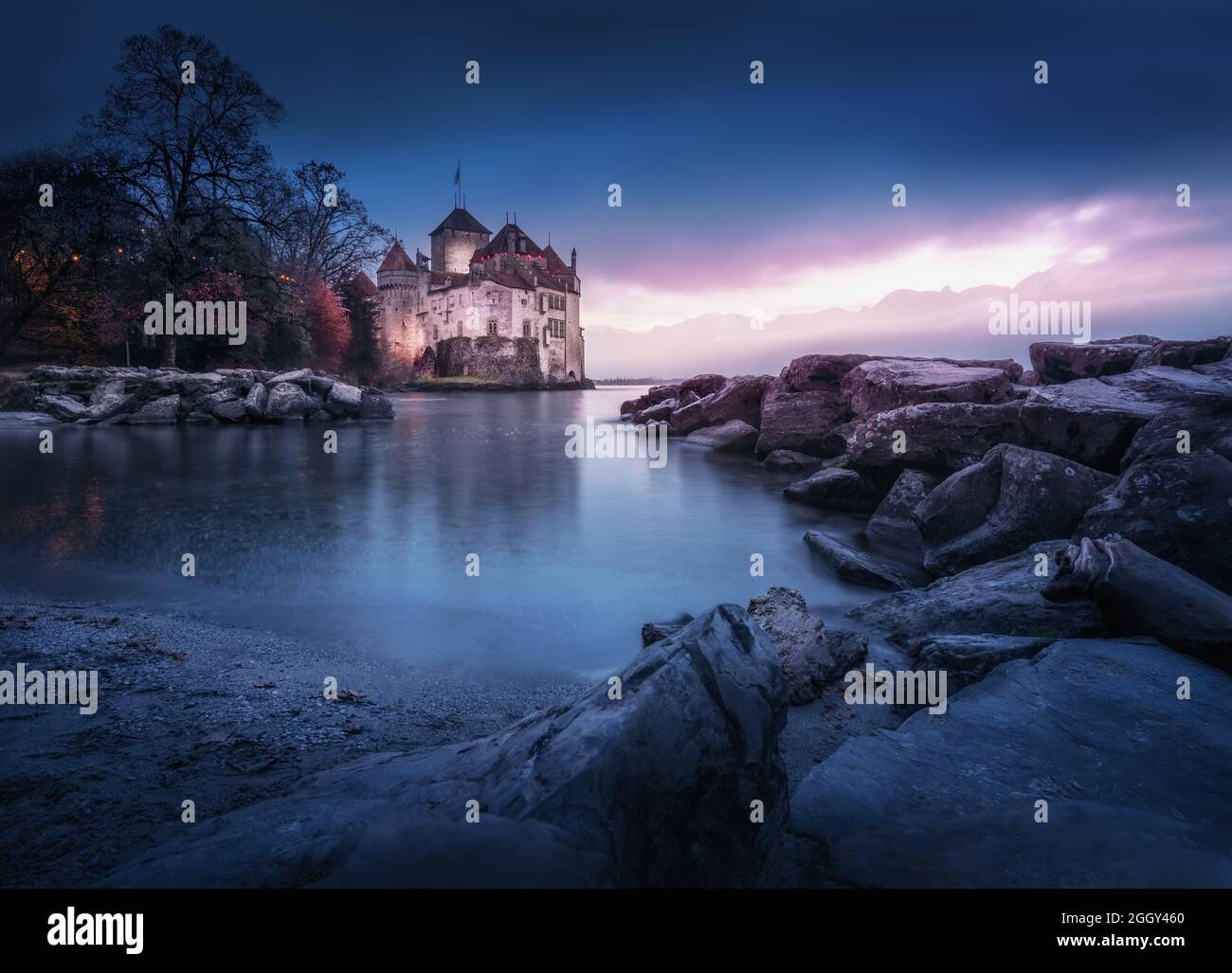 Castello di Chillon illuminato e Lago di Ginevra al tramonto - Cantone di Vaud, Svizzera Foto Stock