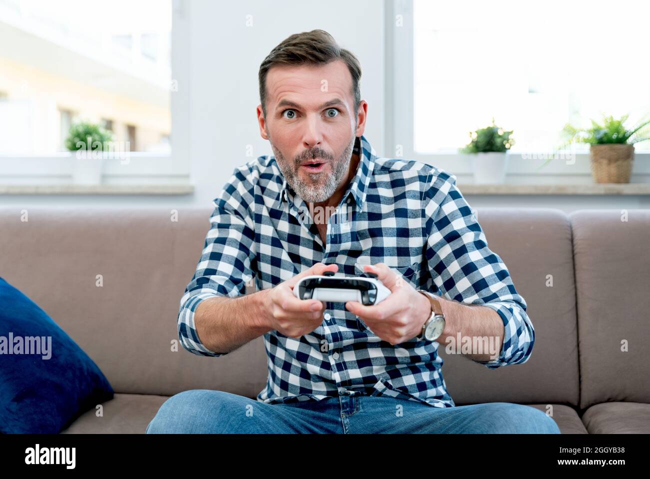 Uomo che gioca ai giochi del computer, che gioca alla console, che tiene i pad nelle mani del. Gioia di giocare ai giochi per computer Foto Stock