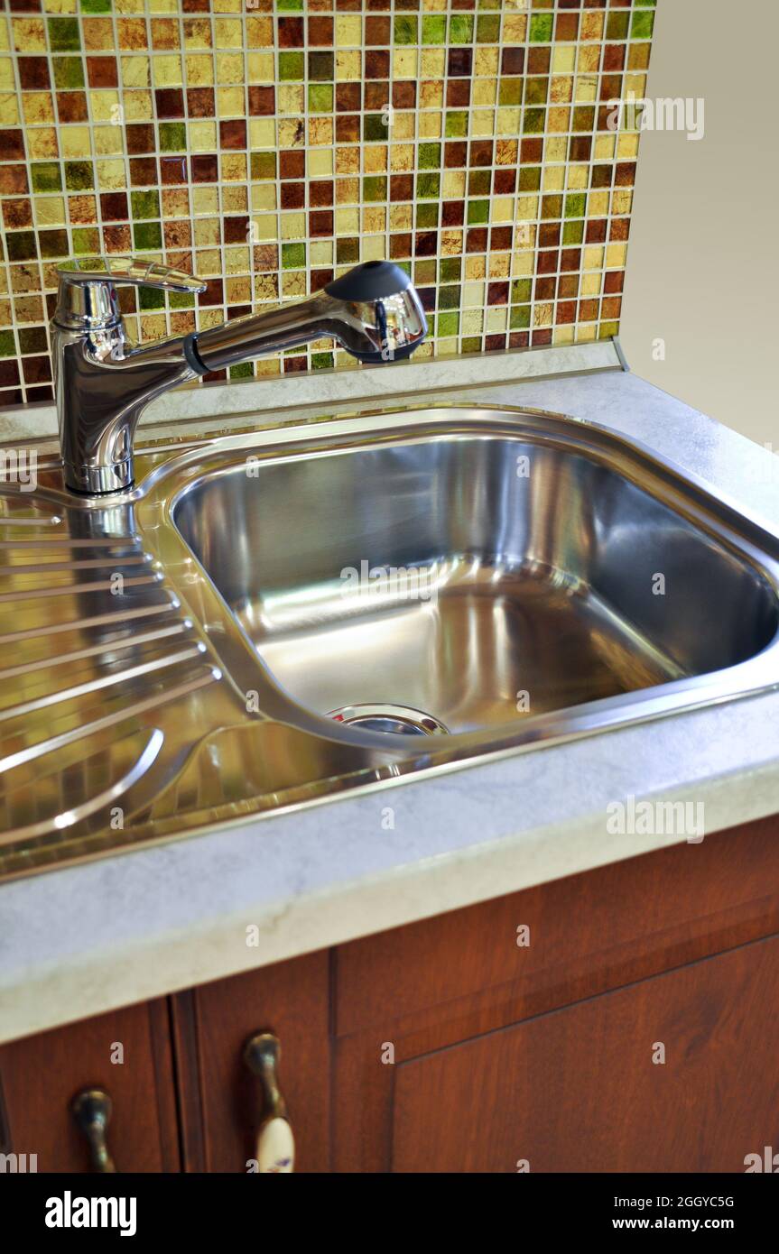Interno di lussuosa cucina moderna e lavandino, rubinetto e scarico in acciaio inossidabile Foto Stock