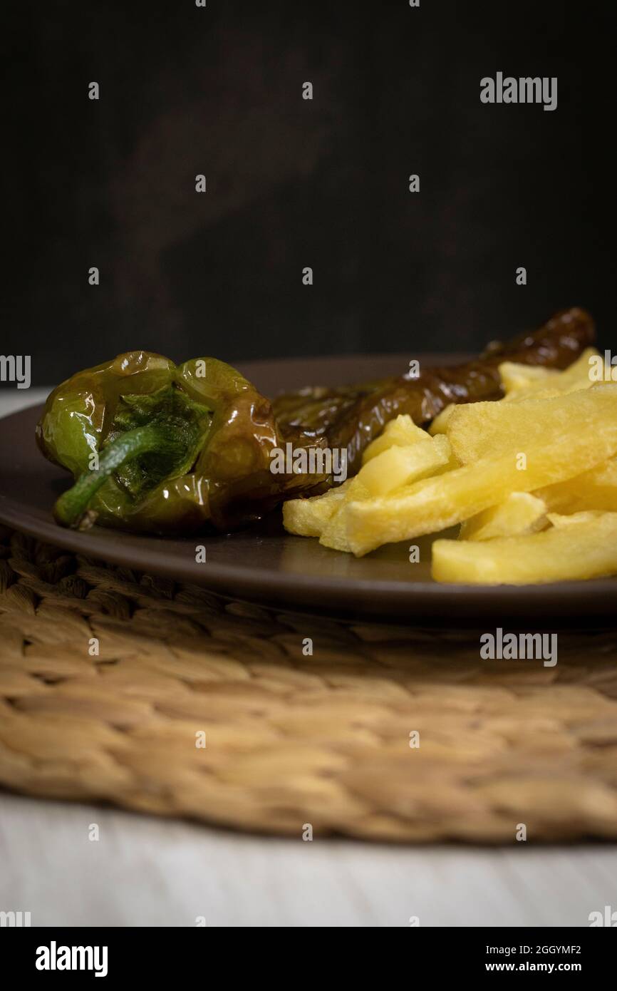 Patatine fritte con peperoni fritti, un alimento molto popolare nel sud della Spagna. Le patate non devono essere congelate e tutte fatte in casa. Tutto fatto con olio d'oliva. Foto Stock