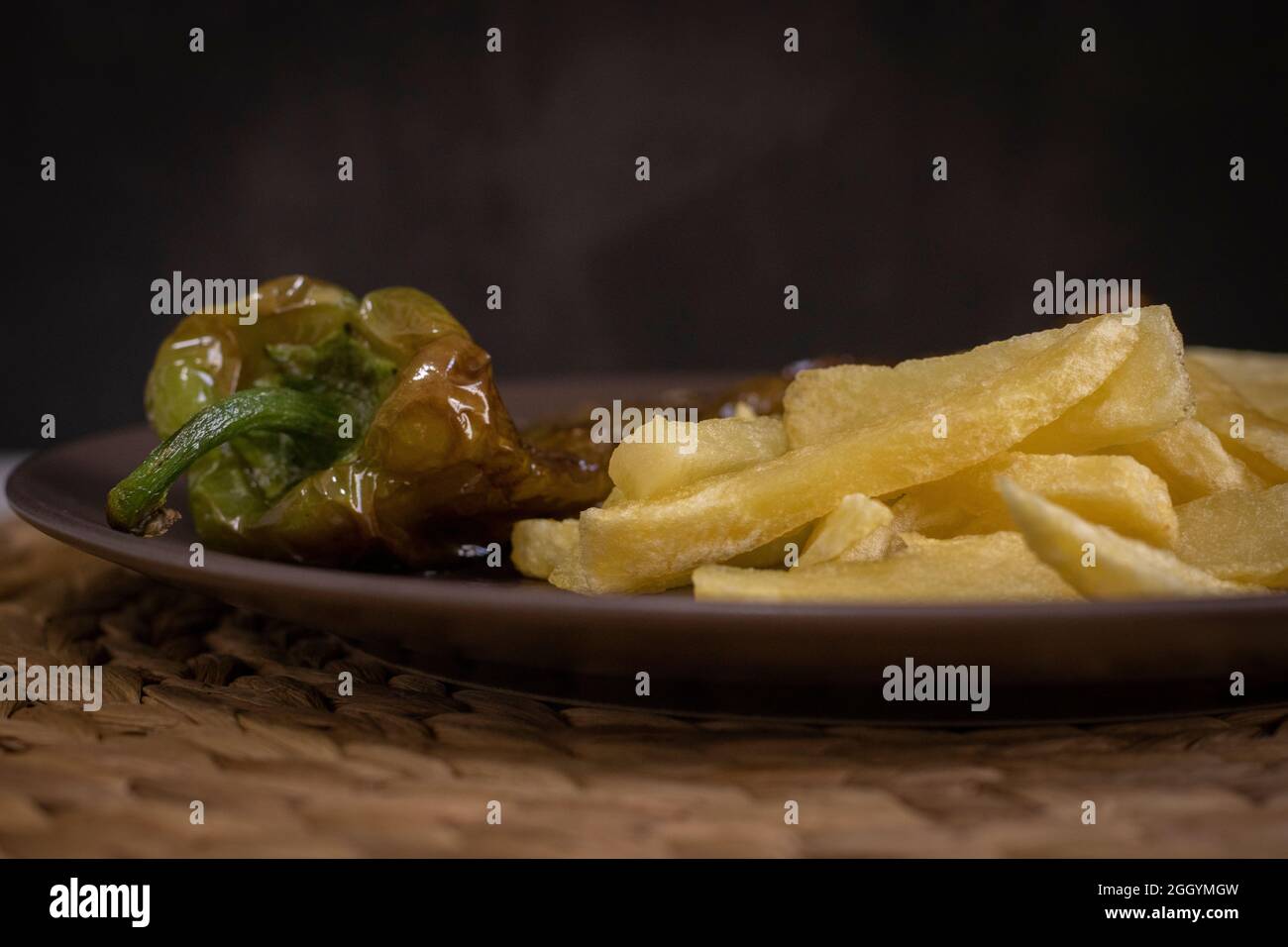 Patatine fritte con peperoni fritti, un alimento molto popolare nel sud della Spagna. Le patate non devono essere congelate e tutte fatte in casa. Tutto fatto con olio d'oliva. Foto Stock