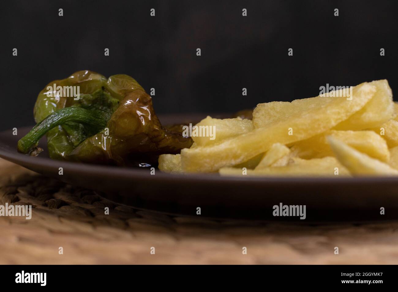 Patatine fritte con peperoni fritti, un alimento molto popolare nel sud della Spagna. Le patate non devono essere congelate e tutte fatte in casa. Tutto fatto con olio d'oliva. Foto Stock