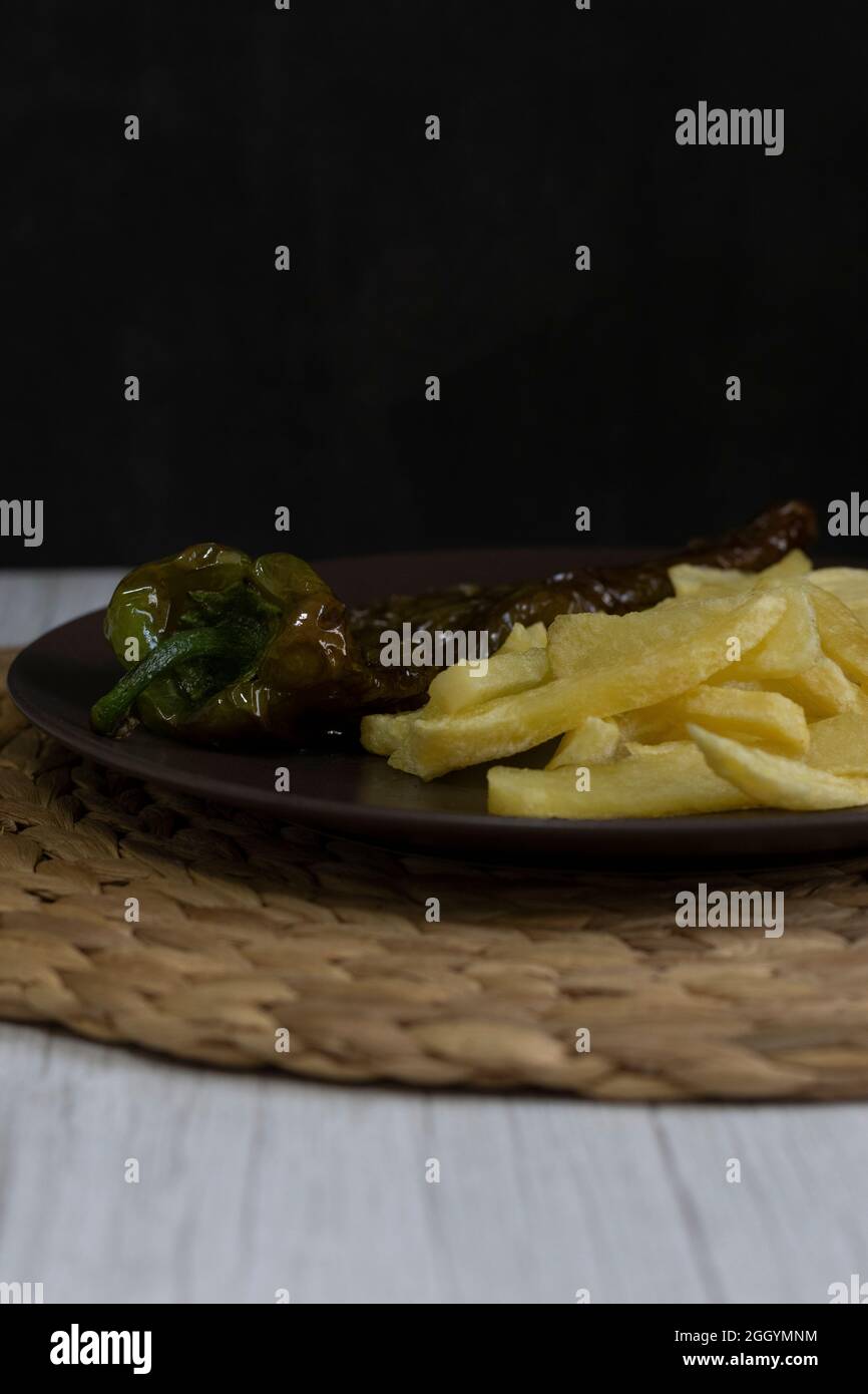 Patatine fritte con peperoni fritti, un alimento molto popolare nel sud della Spagna. Le patate non devono essere congelate e tutte fatte in casa. Tutto fatto con olio d'oliva. Foto Stock