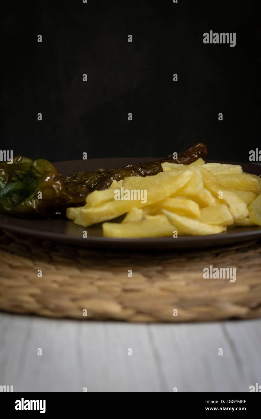 Patatine fritte con peperoni fritti, un alimento molto popolare nel sud della Spagna. Le patate non devono essere congelate e tutte fatte in casa. Tutto fatto con olio d'oliva. Foto Stock