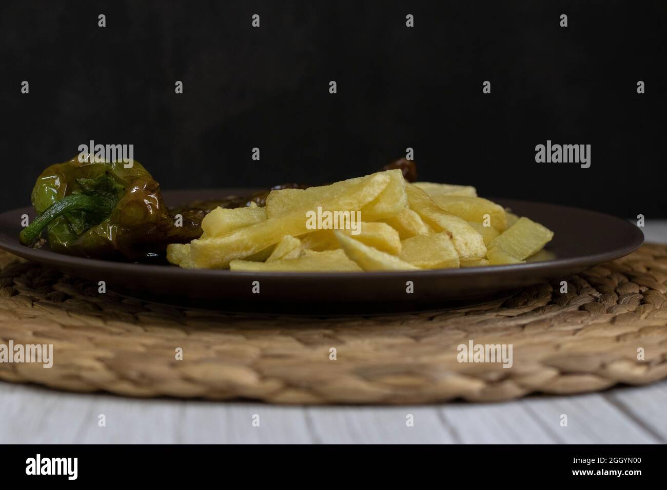 Patatine fritte con peperoni fritti, un alimento molto popolare nel sud della Spagna. Le patate non devono essere congelate e tutte fatte in casa. Tutto fatto con olio d'oliva. Foto Stock