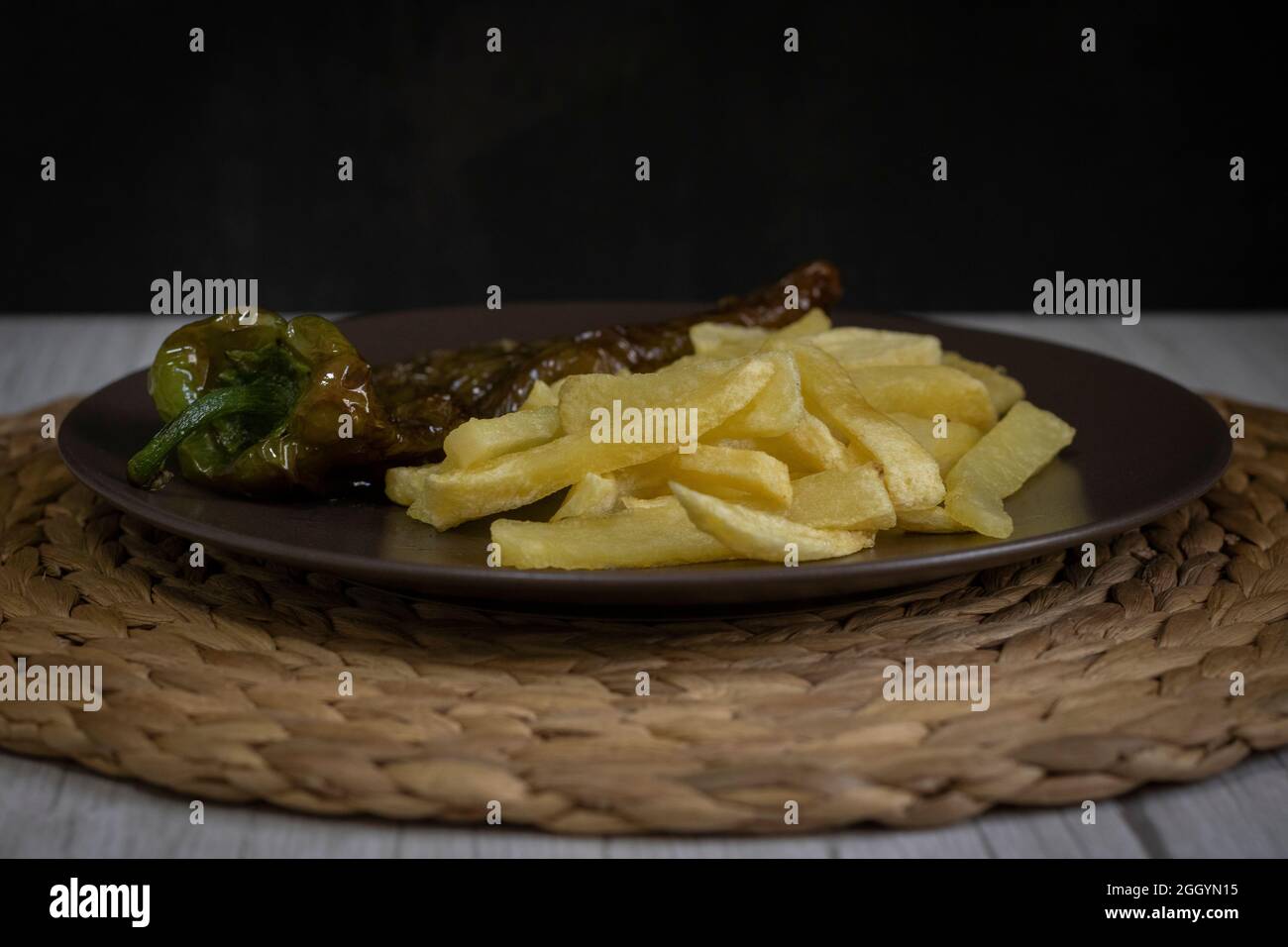 Patatine fritte con peperoni fritti, un alimento molto popolare nel sud della Spagna. Le patate non devono essere congelate e tutte fatte in casa. Tutto fatto con olio d'oliva. Foto Stock