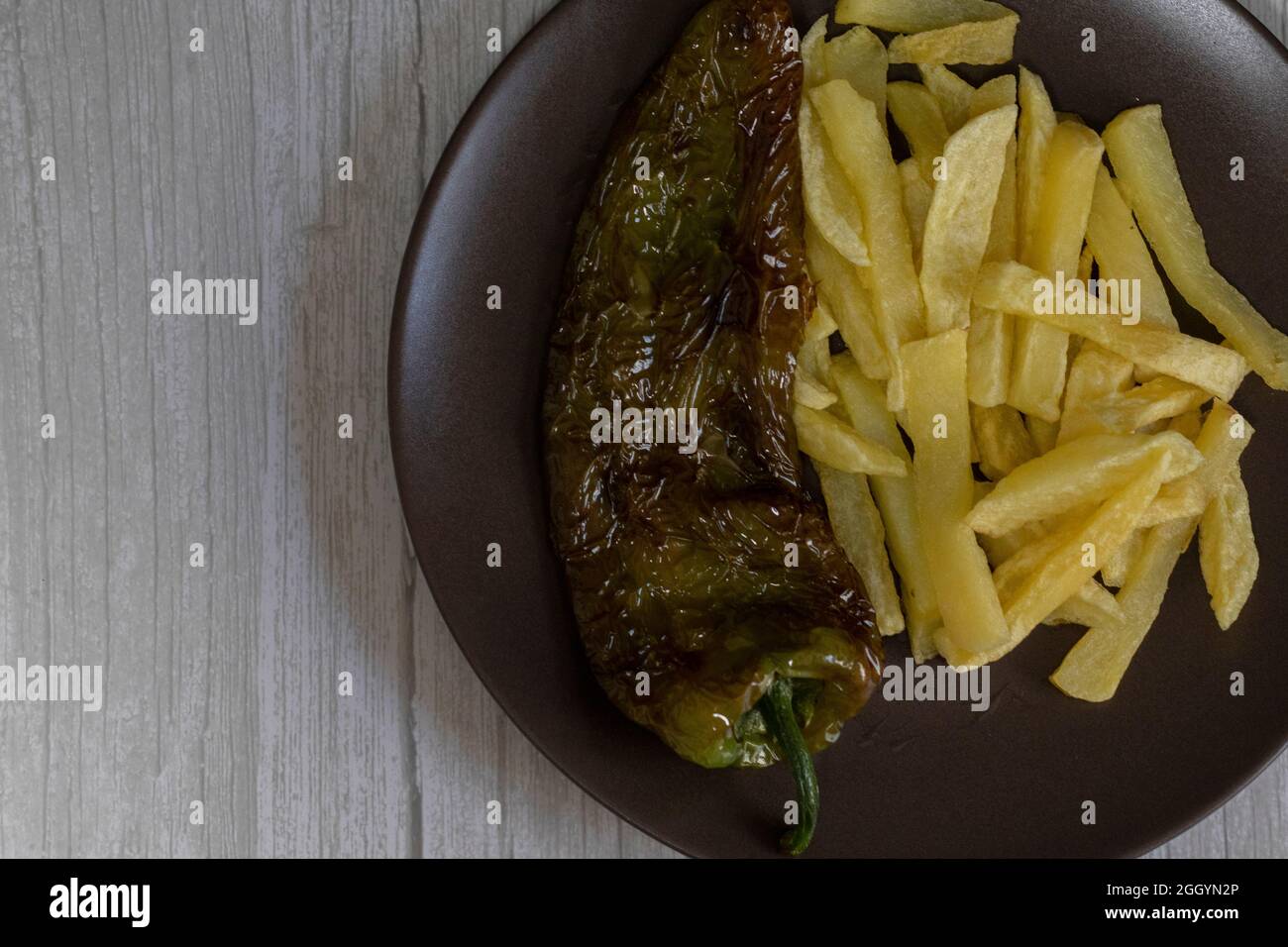 Patatine fritte con peperoni fritti, un alimento molto popolare nel sud della Spagna. Le patate non devono essere congelate e tutte fatte in casa. Tutto fatto con olio d'oliva. Foto Stock