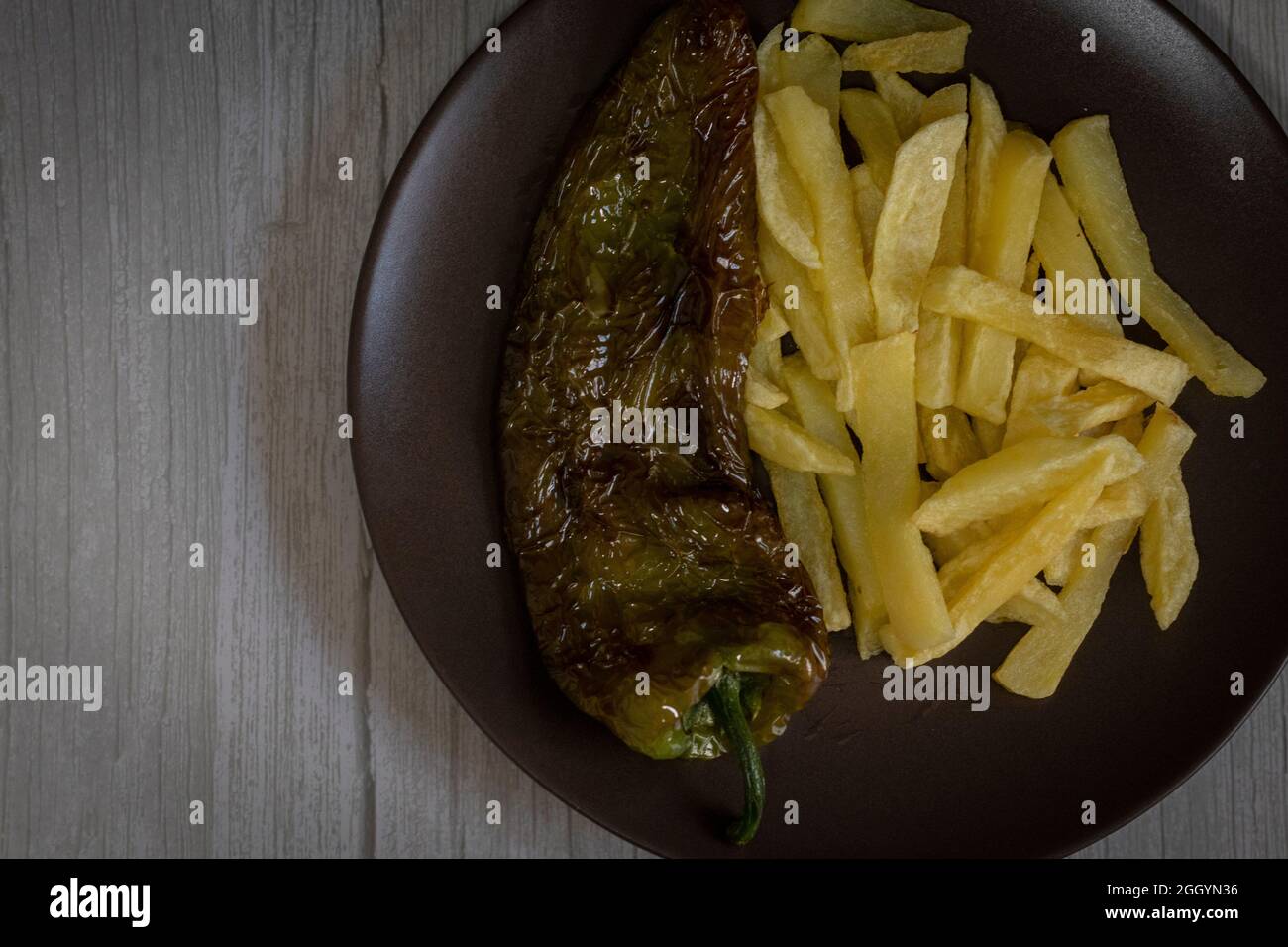 Patatine fritte con peperoni fritti, un alimento molto popolare nel sud della Spagna. Le patate non devono essere congelate e tutte fatte in casa. Tutto fatto con olio d'oliva. Foto Stock