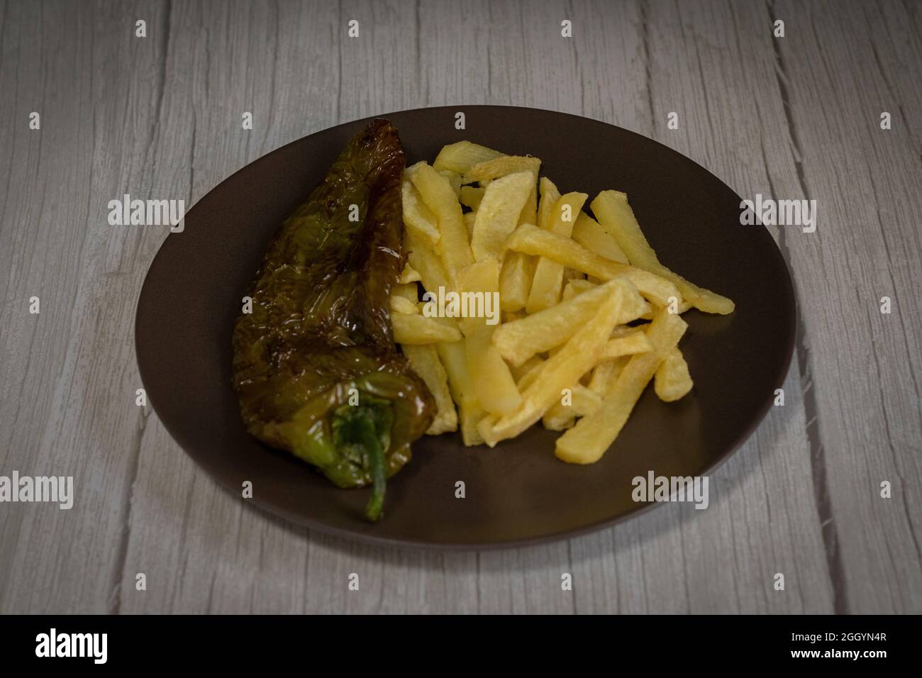 Patatine fritte con peperoni fritti, un alimento molto popolare nel sud della Spagna. Le patate non devono essere congelate e tutte fatte in casa. Tutto fatto con olio d'oliva. Foto Stock