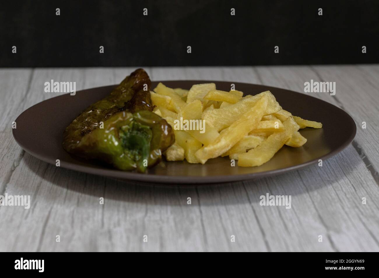 Patatine fritte con peperoni fritti, un alimento molto popolare nel sud della Spagna. Le patate non devono essere congelate e tutte fatte in casa. Tutto fatto con olio d'oliva. Foto Stock