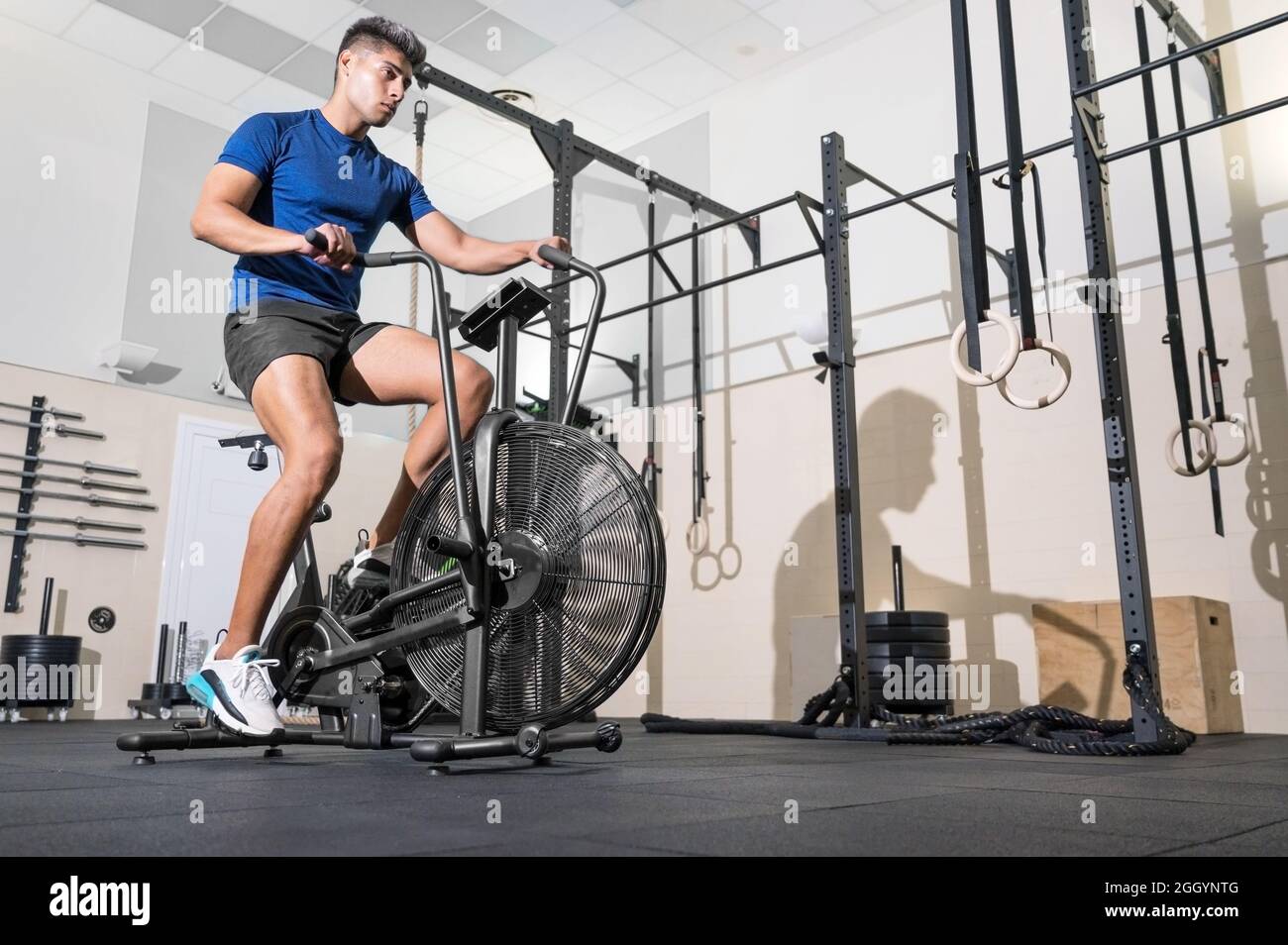 Fit uomo che fa allenamento cardio su macchina cyclette con ventilatore in  palestra. Foto di alta qualità Foto stock - Alamy