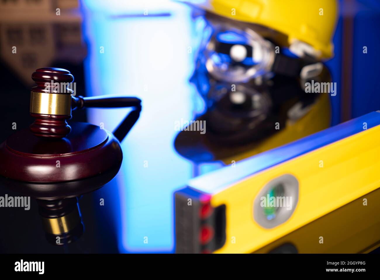Concetto di legge di costruzione. Casco e Gavel del giudice su sfondo grigio. Foto Stock