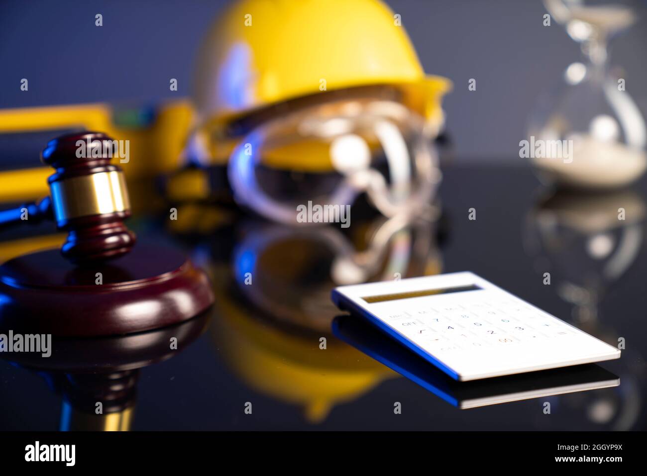 Concetto di legge di costruzione. Casco e Gavel del giudice su sfondo grigio. Foto Stock