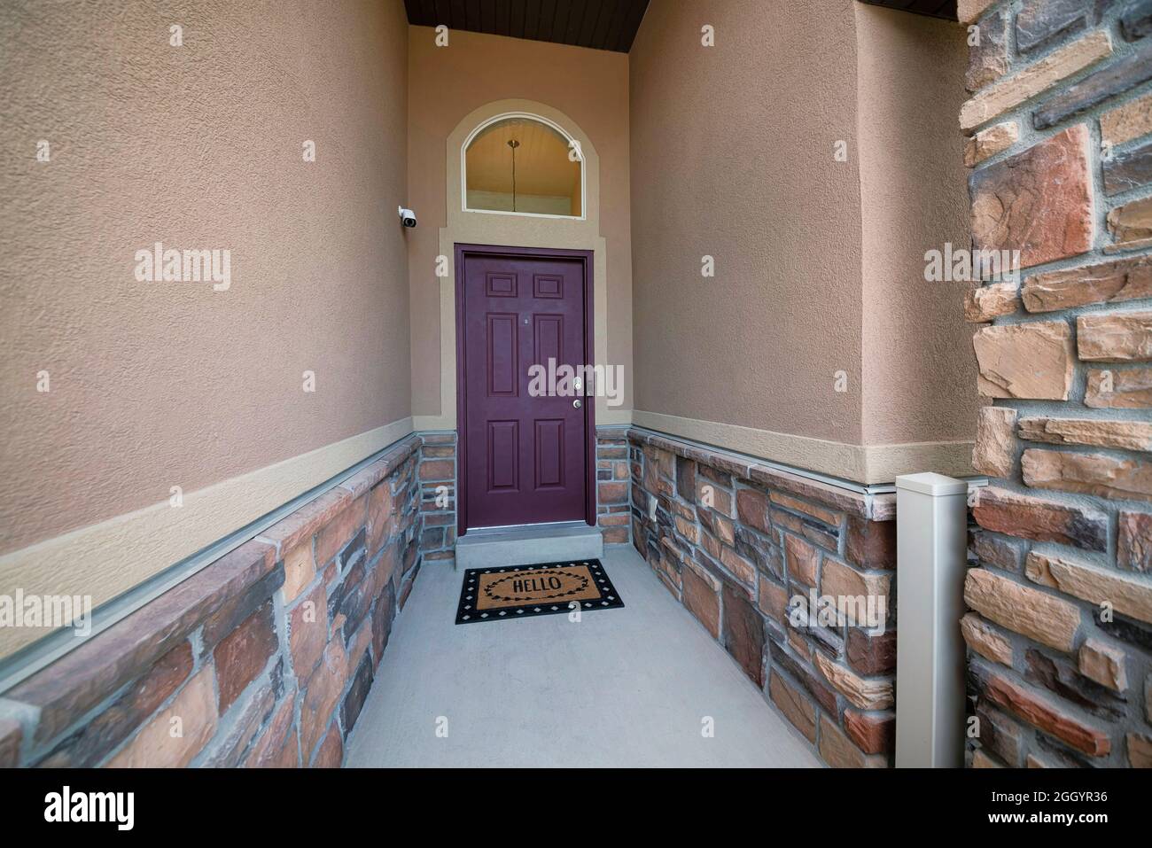 Stretto ingresso in cemento di una casa con una macchina fotografica di sicurezza Foto Stock