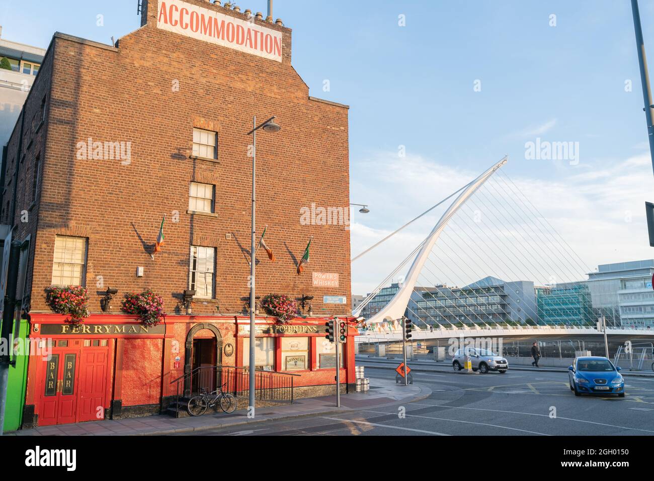 Dublino, IRLANDA - AGOSTO 10 2017; Ferryman vecchio hotel in mattoni sul lato del fiume Liffey con il ponte Harp sullo sfondo. Foto Stock