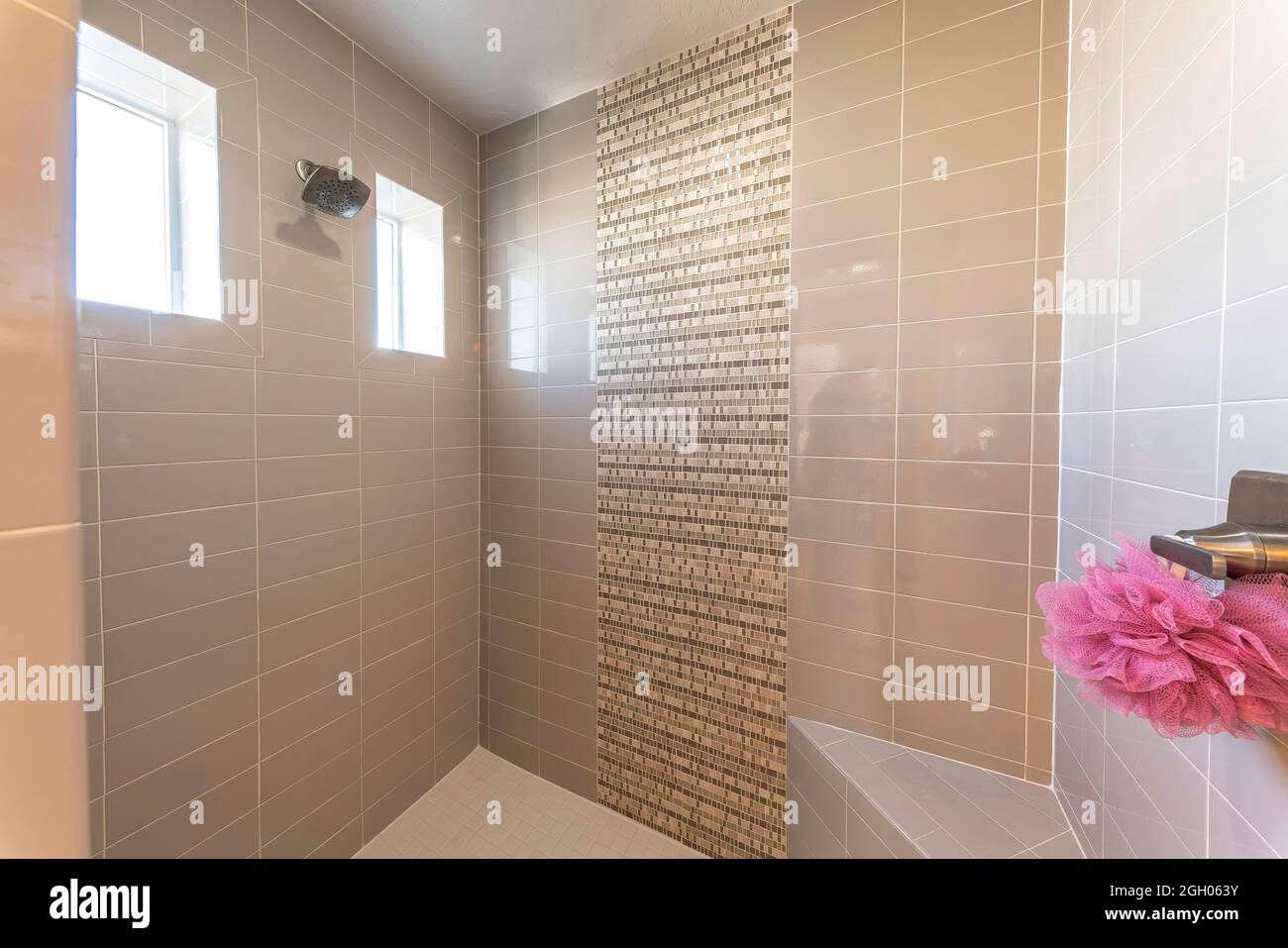 Interno di un bagno con doccia a parete e finestre Foto Stock