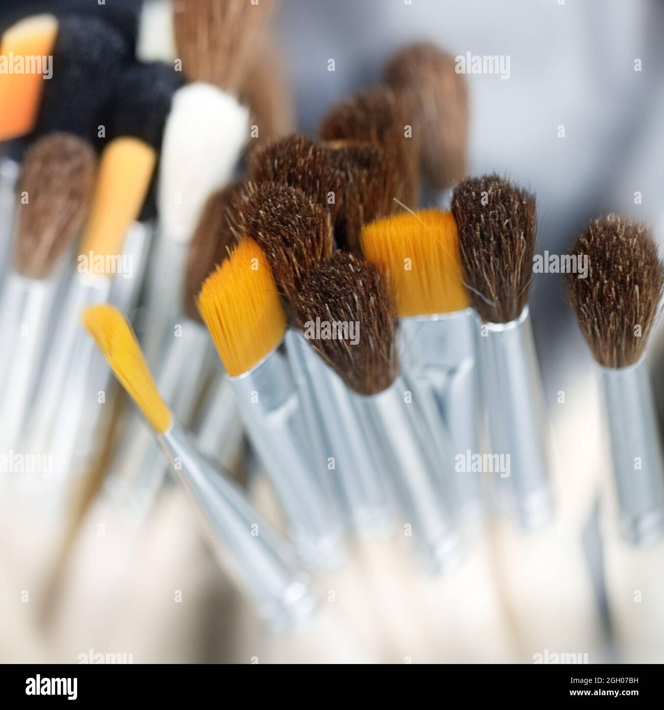 Pennelli per pittura. Primo piano di diversi nuovi pennelli da pittura su sfondo scuro con bokeh, messa a fuoco morbida. Foto Stock