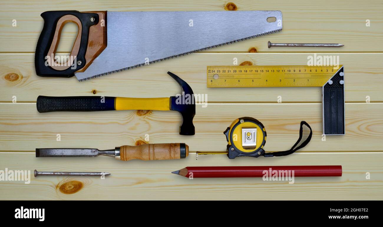 Metro a nastro per sega a martello prova la collezione di utensili per lavorazione del legno a matita quadrata e scalpello su un banco di lavoro in legno Foto Stock