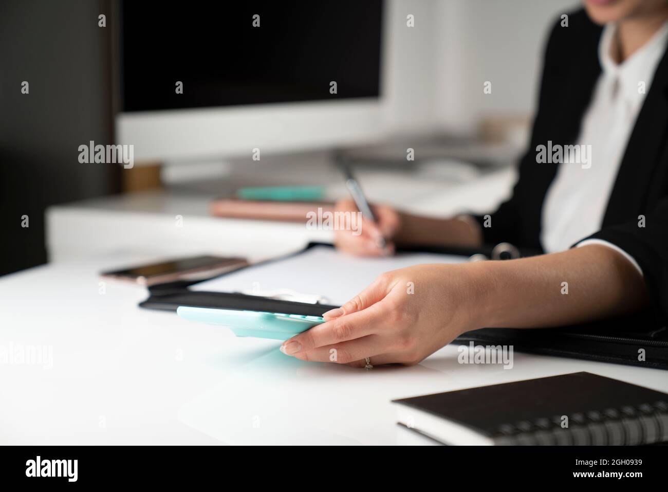 Donna d'affari nell'ufficio corporativo.giovane donna d'affari seduta sul suo posto di lavoro e guardando i documenti nell'ufficio. Foto Stock