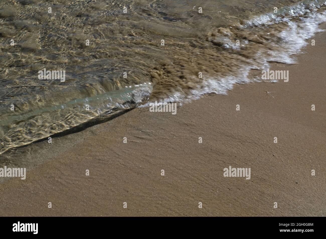 Primo piano di una bella spiaggia di sabbia con acque limpide attraverso il mare in iOS Grecia Foto Stock