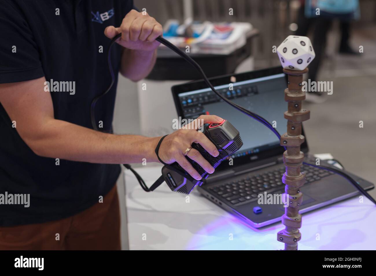 Poznan, Polonia 01 Sep 2021:ITM Industry Europe, High-tech EXPO. Uomo che utilizza scanner laser portatile per importare un modello CAD 3D. Reverse engineering. Foto Stock