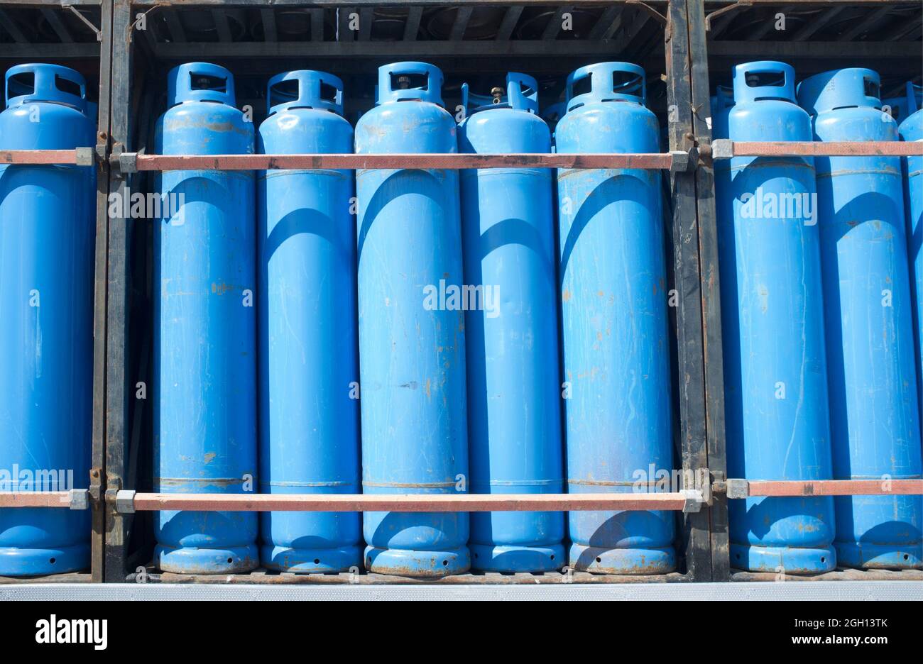Carichi di bombole blu di gas propano assortite su un camion. Trasporto di materiali pericolosi. Foto Stock