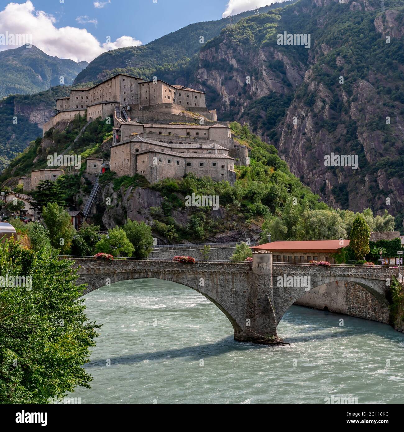 Il fiume Dora Baltea scorre sotto la collina del Forte di Bard, Valle d'Aosta, Italia Foto Stock