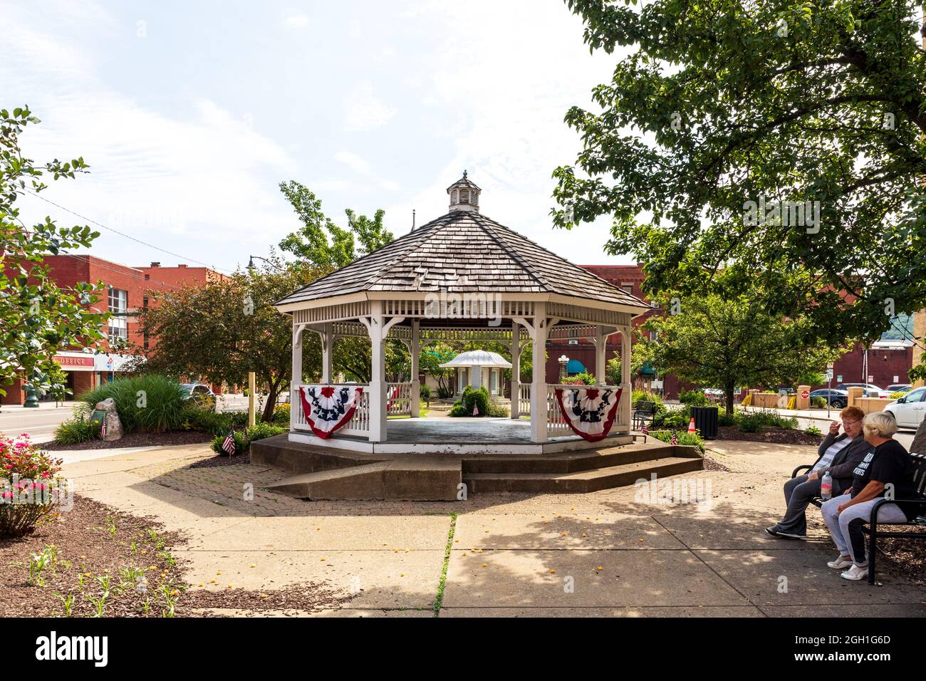 BRADFORD, PA, USA-13 AGOSTO 2021: Un parco cittadino, con un gazebo e due donne sedute su una panchina. Foto Stock