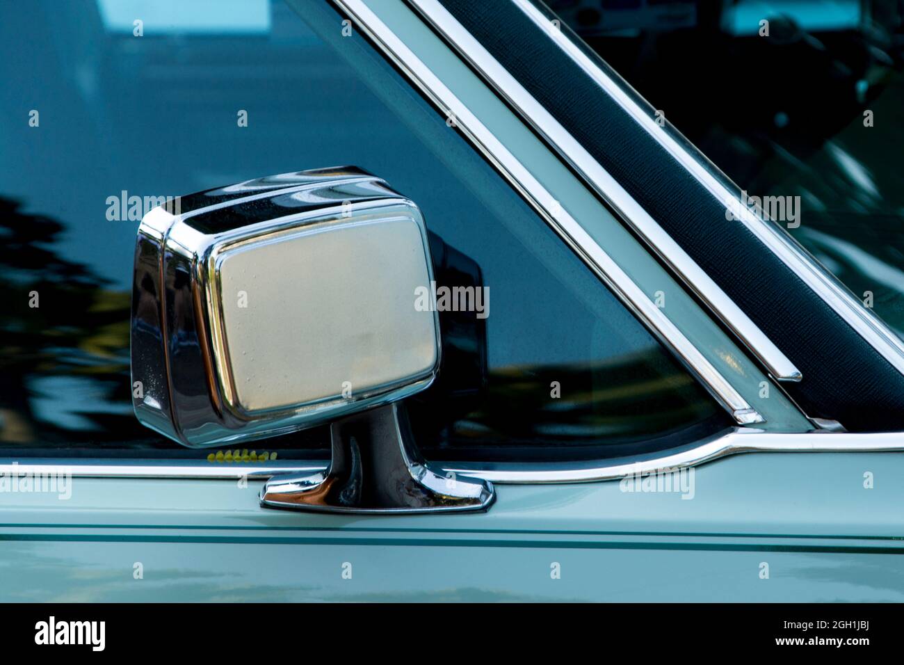 Dettaglio di uno specchietto retrovisore di un'auto vintage di colore ciano. Salvador Bahia Brasile. Foto Stock