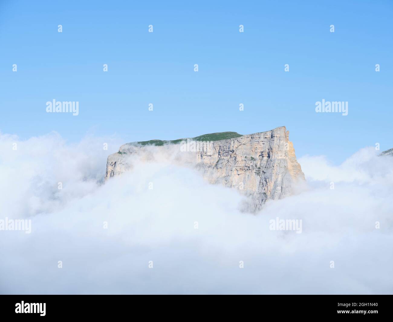 VISTA AEREA. Mont Aiguille, un butte calcareo isolato che emerge da un mare di nuvole. Saint-Martin de Clelles, Monte Vercors, Isère, Francia. Foto Stock