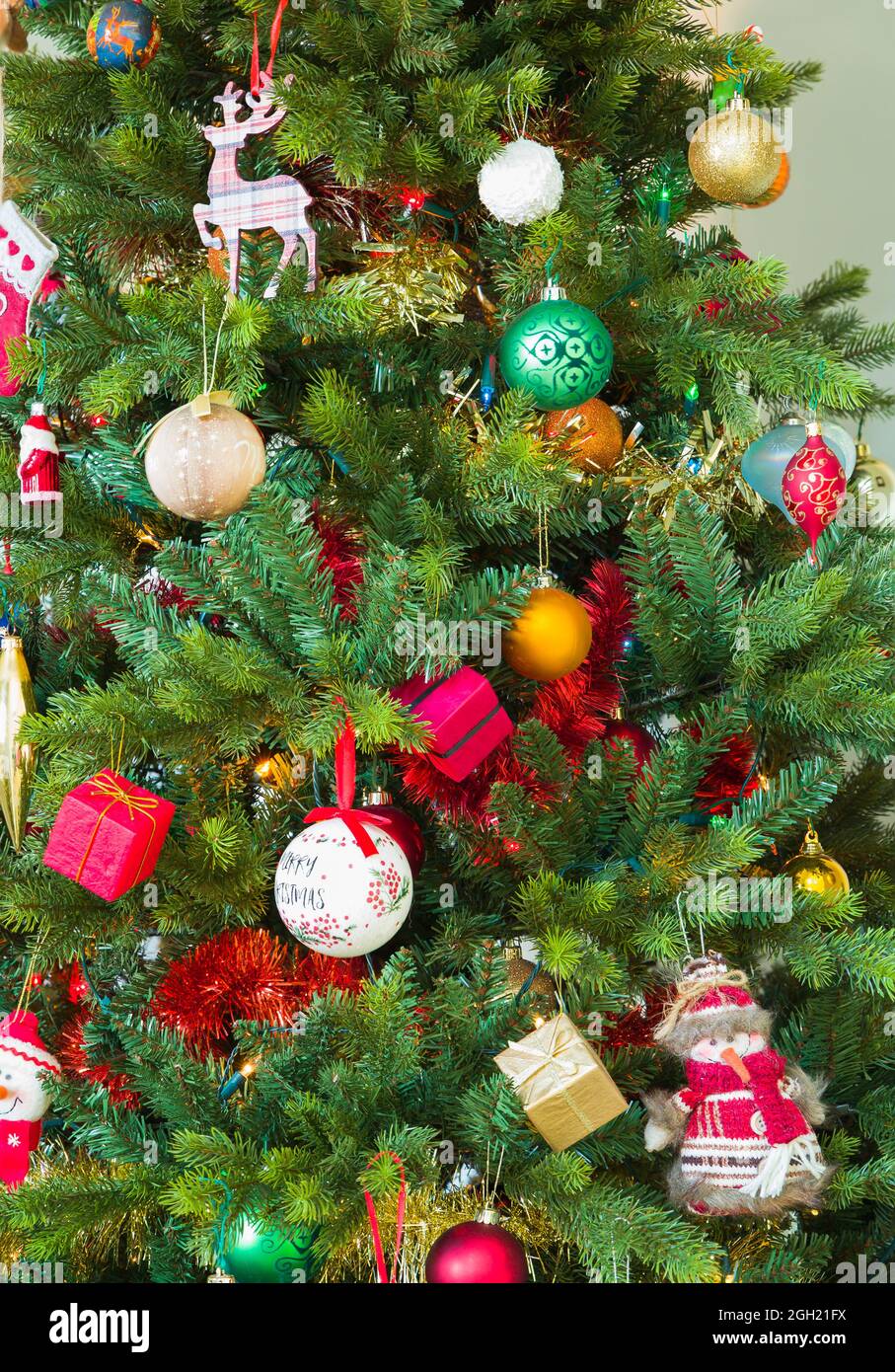 Albero di Natale decorato con decorazioni, ornamenti e baubles in una casa, Regno Unito Foto Stock