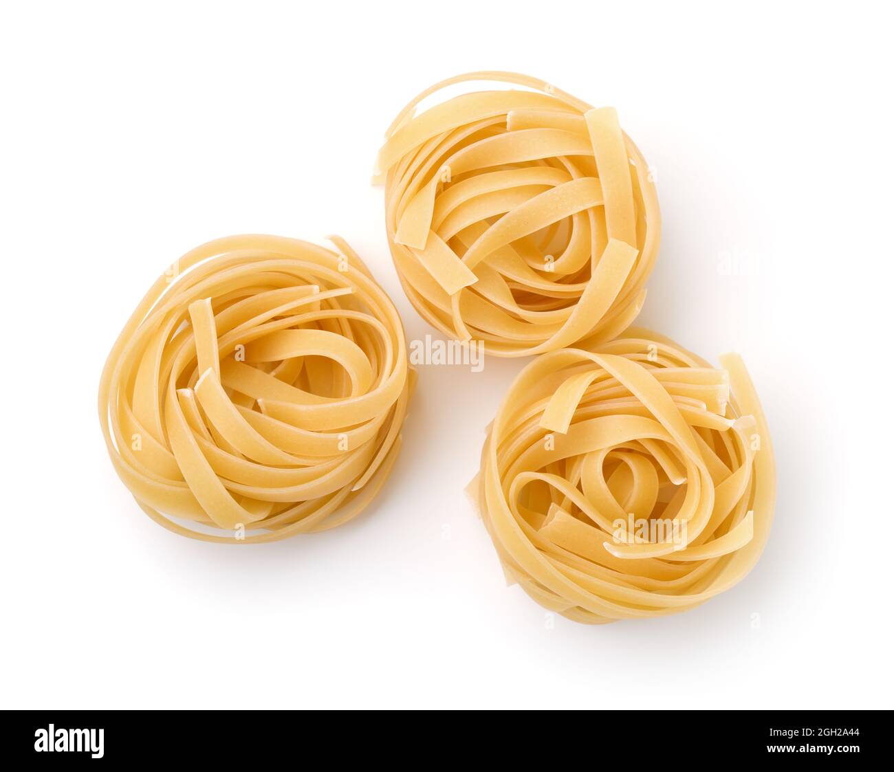 Vista dall'alto di tre nidi di pasta a nastro tagliatelle non cotti isolati su bianco Foto Stock