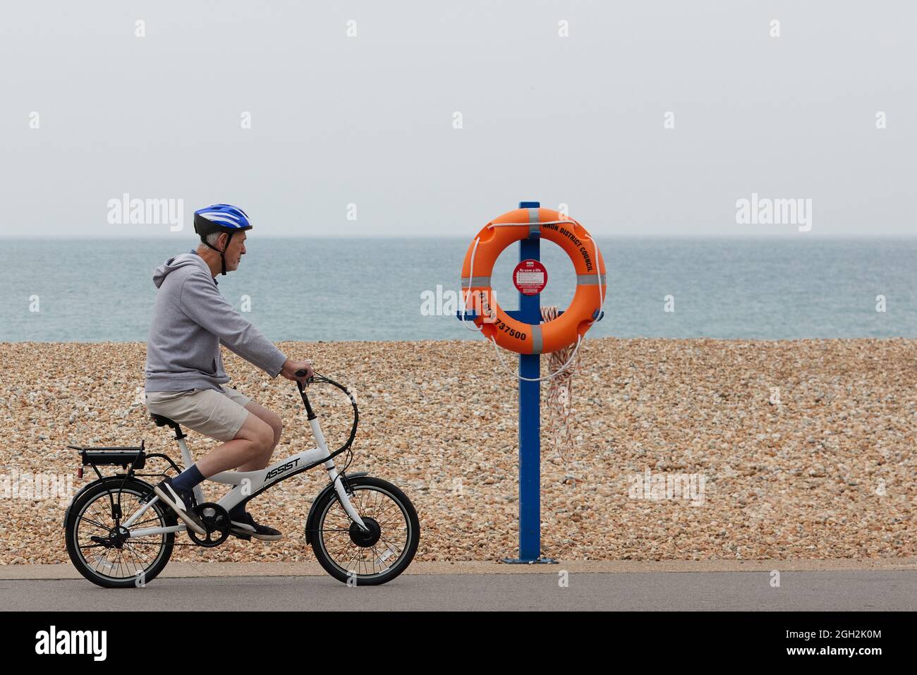 Uomo in bicicletta lungo la spiaggia. Foto Stock