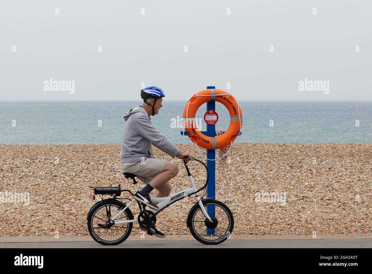 Uomo in bicicletta lungo la spiaggia. Foto Stock