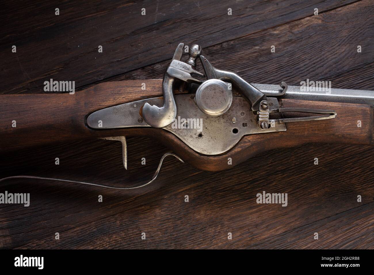 antico muschio di flintlock del xvii secolo con fiasca di polvere e pallottole a led su ponte di legno. Foto Stock