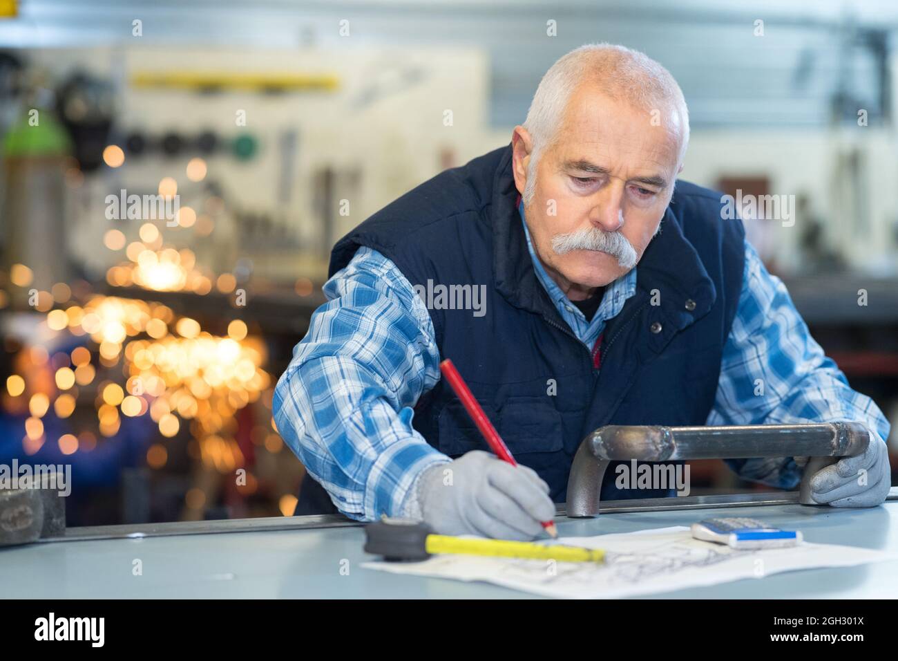 saldatore che fa o migliora i suoi disegni Foto Stock