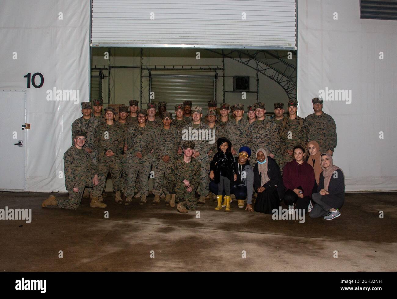 I Marines degli Stati Uniti con il reggimento logistico di combattimento 2 e i membri dell'Associazione Musulmana della Virginia, Masjid Daral Noor, posano per una foto sulla base del corpo Marino Quantico, Virginia, 1 settembre 2021. Il Dipartimento della Difesa, attraverso il comando del Nord degli Stati Uniti, e a sostegno del Dipartimento della sicurezza interna, sta fornendo trasporto, alloggio temporaneo, screening medico, e supporto generale per almeno 50,000 sfollati afghani in strutture adeguate, in strutture permanenti o temporanee, il più rapidamente possibile. Questa iniziativa fornisce al personale afghano un sostegno essenziale in luoghi sicuri all'esterno Foto Stock