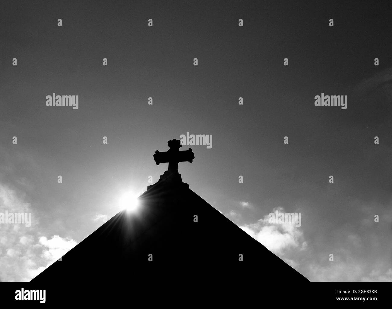 Il morninglsun sorge dietro la croce di pietra in cima ad una chiesa cattolica, la Basilica Cattedrale di San Francesco d'Assisi, a Santa Fe, New Mexico. Foto Stock