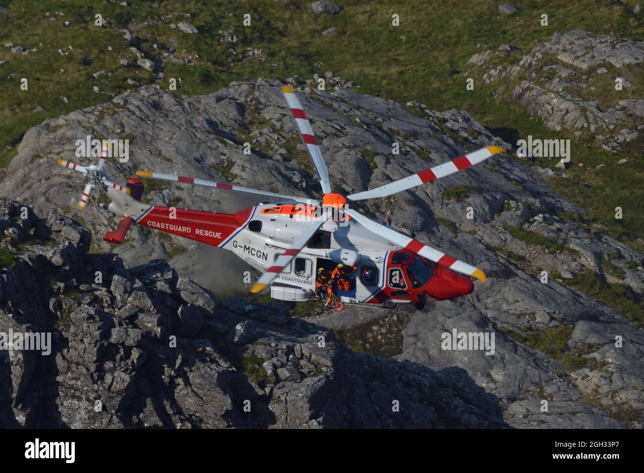 Un elicottero AW189 della guardia costiera di sua Maestà che effettua un salvataggio in montagna sulla faccia nord di ben Nevis, Highlands scozzesi, Regno Unito Foto Stock