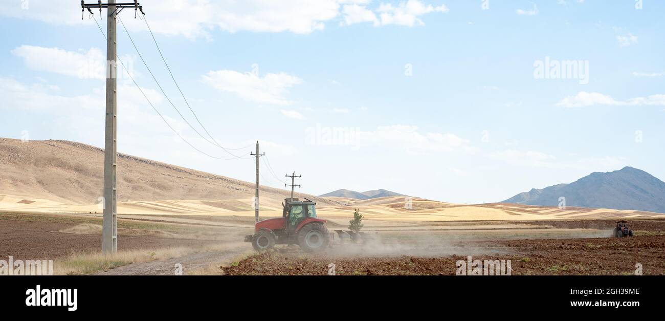 Vecchio trattore che lavora sul campo arato, campo di grano, in iran Foto Stock