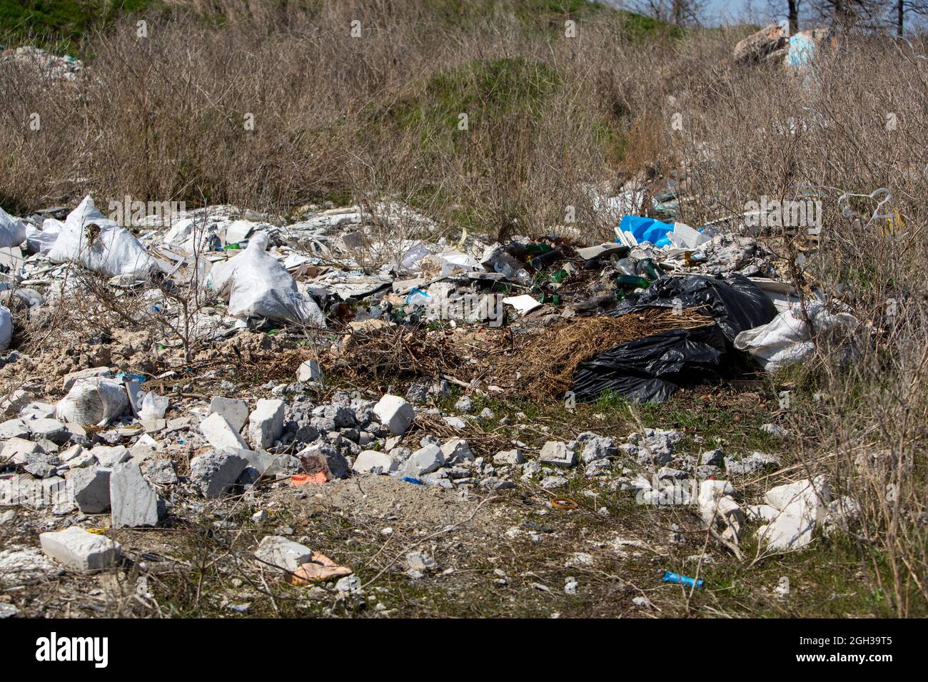 Cosparsi di campi di spazzatura e strade. Caminetti da rifiuti e pneumatici ruote. Plastica, polietilene, bottiglie, sacchetto per la casa e la costruzione Foto Stock