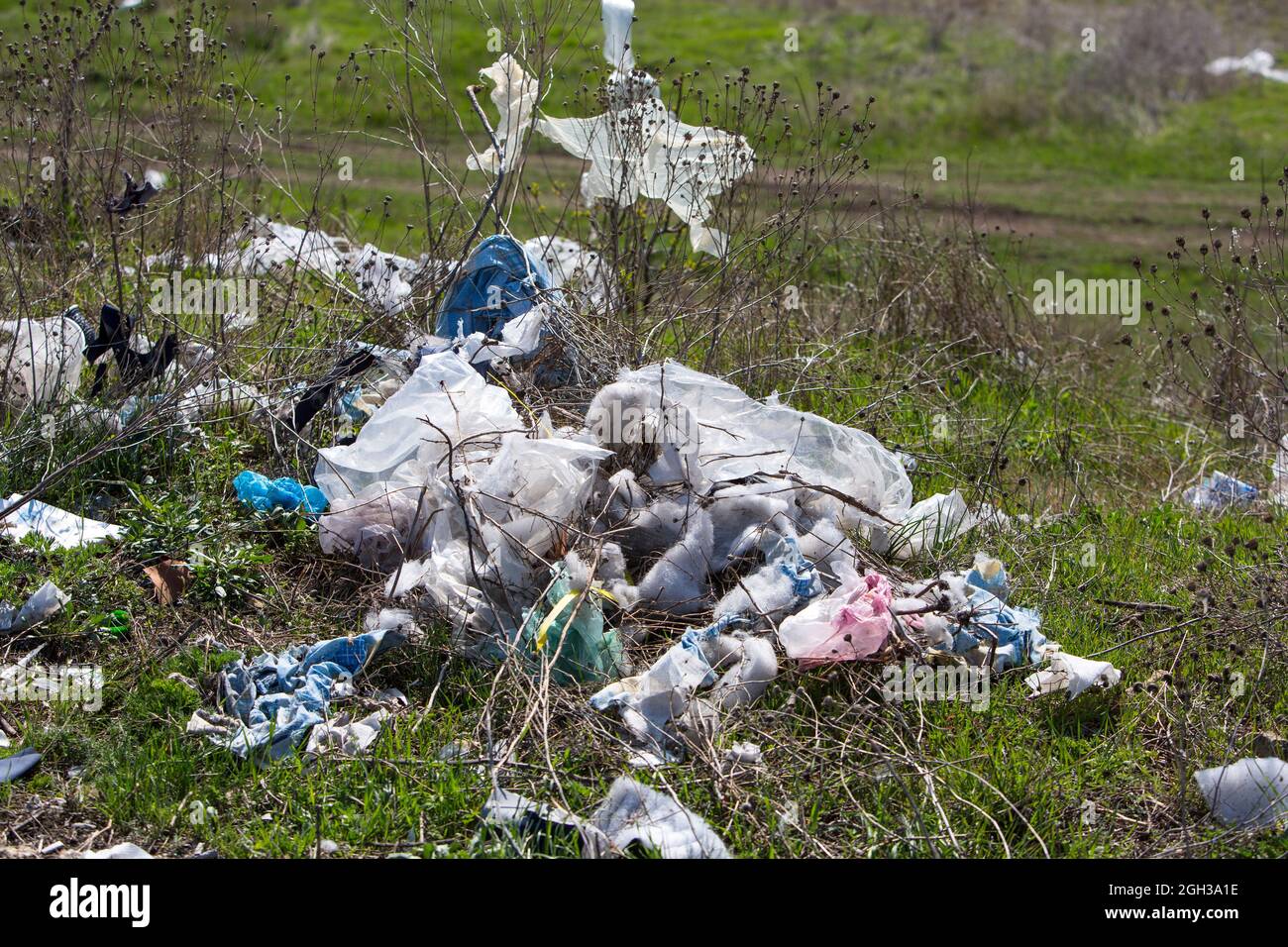 Cosparsi di campi di spazzatura e strade. Caminetti da rifiuti e pneumatici ruote. Plastica, polietilene, bottiglie, sacchetto per la casa e la costruzione Foto Stock