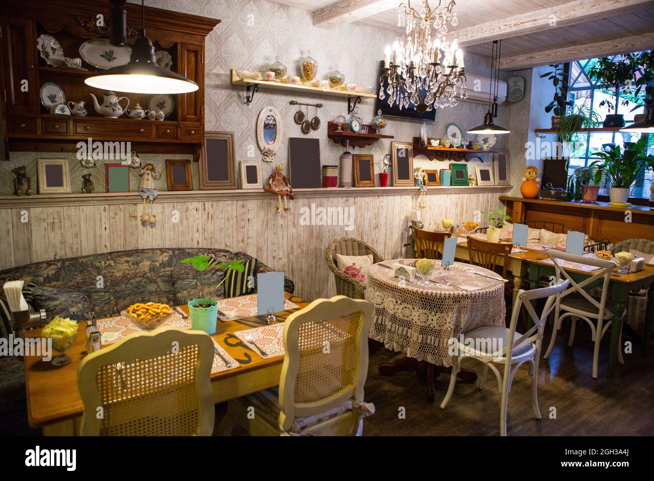 Interno del ristorante in stile country. Accogliente ristorante in stile francese con cornici vuote per dipinti e fotografie sulle pareti Foto Stock