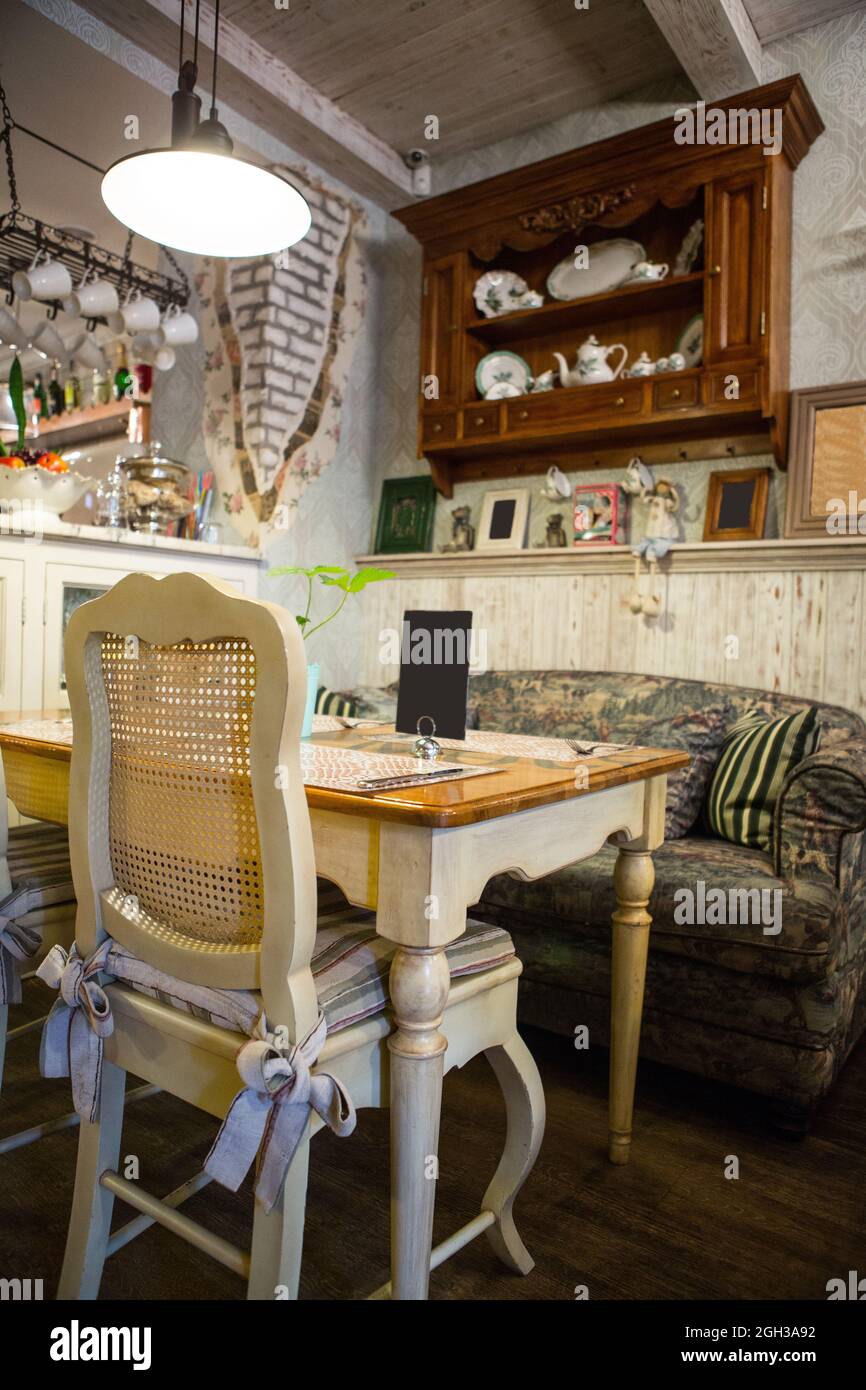 Interno del ristorante in stile country. Accogliente ristorante in stile francese con cornici vuote per dipinti e fotografie sulle pareti Foto Stock