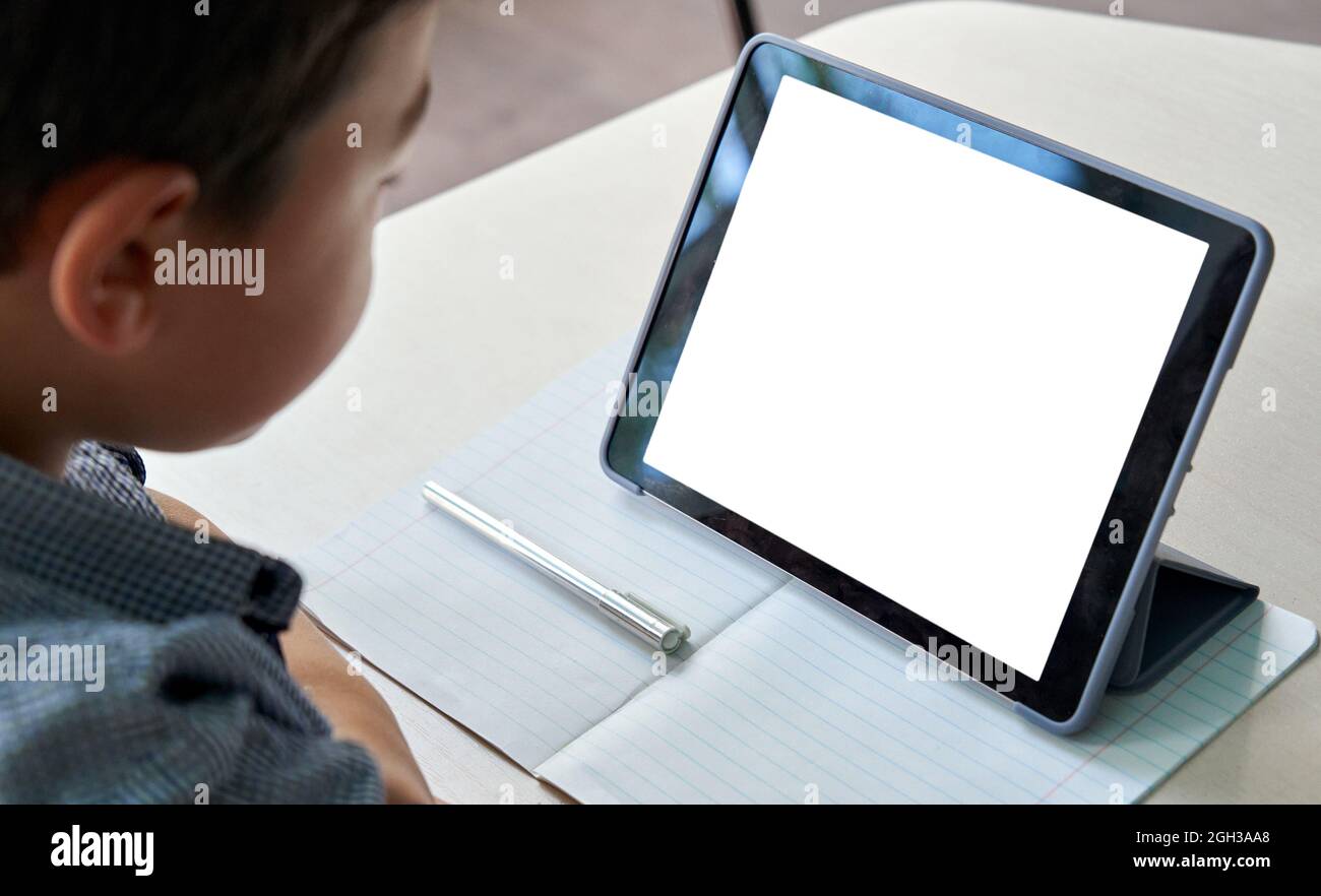 Studente ragazzo della scuola asiatica che usa un mockup digitale bianco tablet. Foto Stock